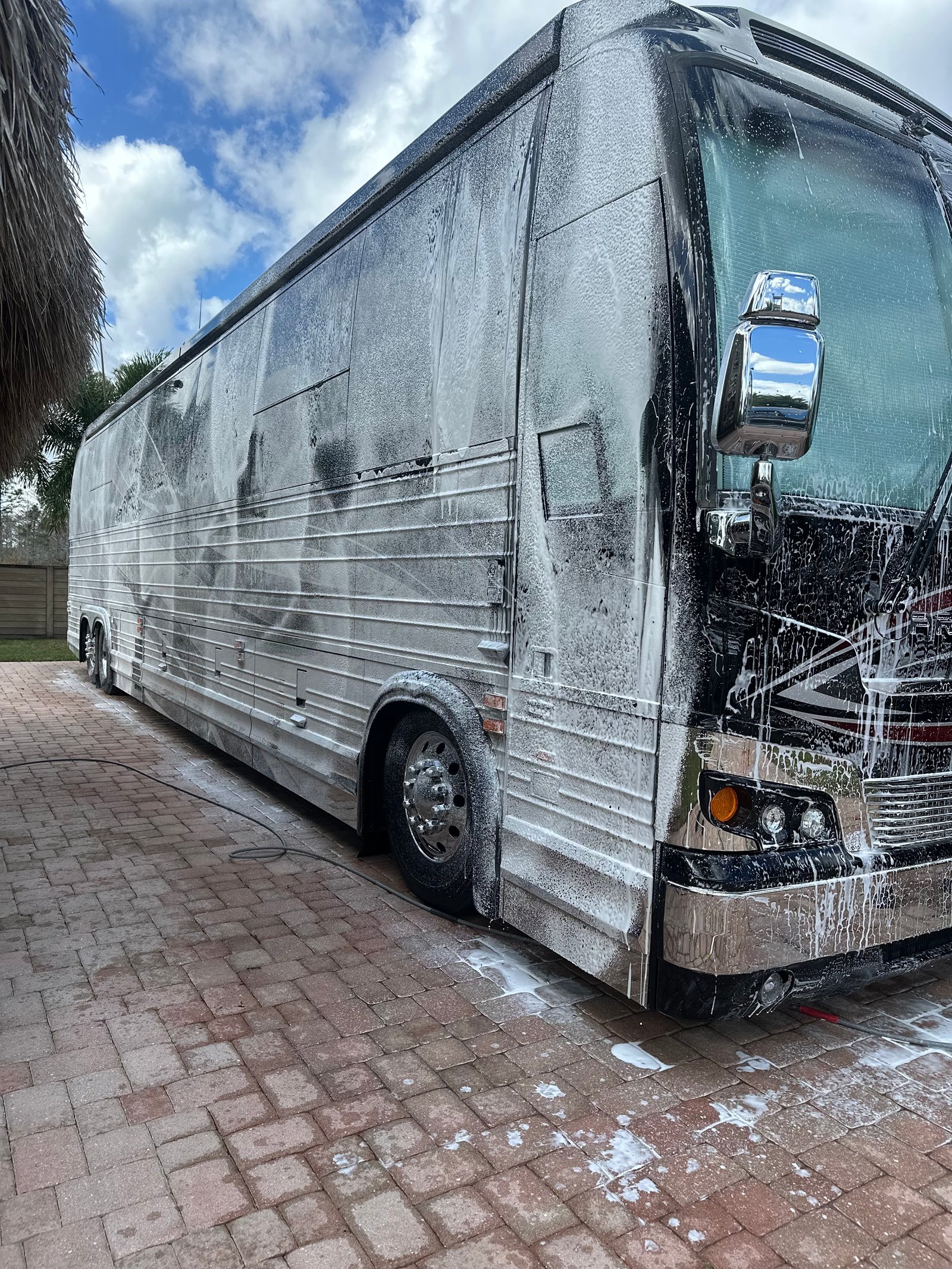 Professional RV detailing service - A large RV being detailed with soap and cleaning products